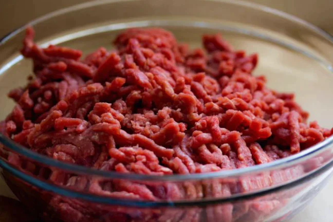 Fresh grass fed ground beef from New York Prime Beef in a glass bowl, raw and ready to cook