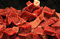 Raw beef stew cubes from New York Prime Beef with visible marbling and seasoning, ideal for stews, soups, and braised dishes.