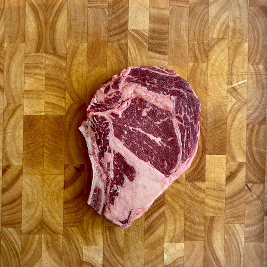 Kosher bone-in ribeye steak raw vacuum sealed with heavy marbling, premium steakhouse cut for grilling or pan searing
